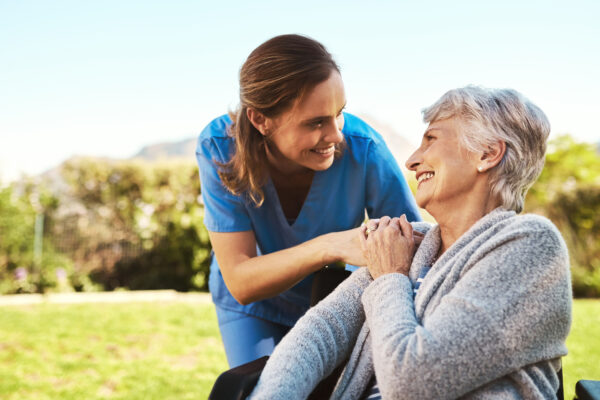 Cropped shot of a young female nurse outside with a senior patient in a wheelchair.