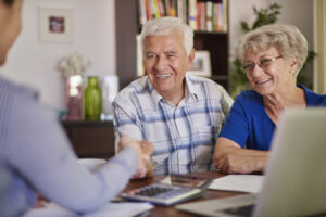 Elderly couple sitting at table reviewing support at home prices