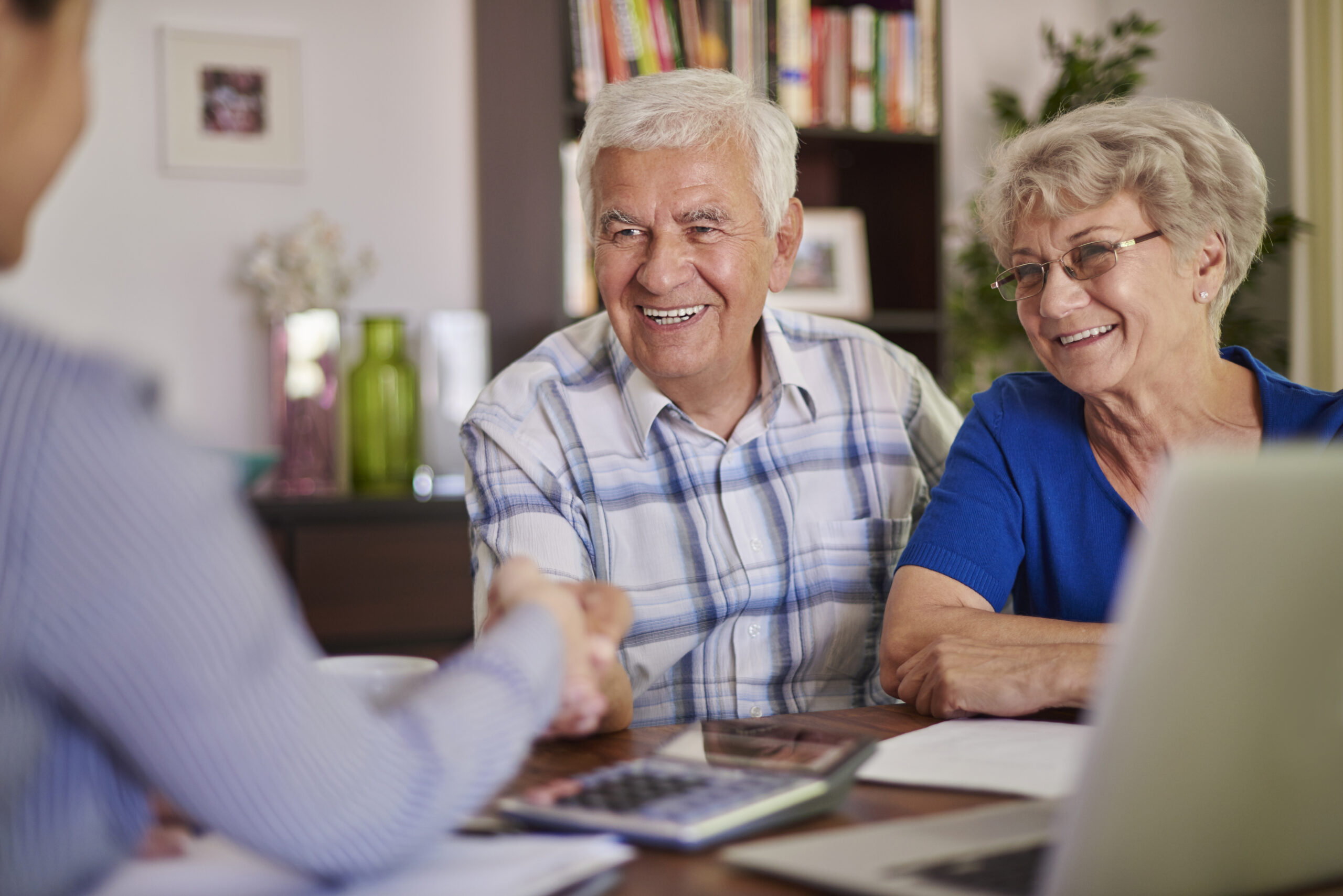 Elderly couple sitting at table reviewing support at home prices