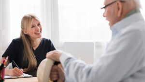 Elderly man with carer in office doing a care plan review