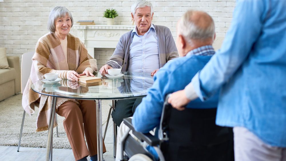 Seniors sitting around a table in an aged care home
