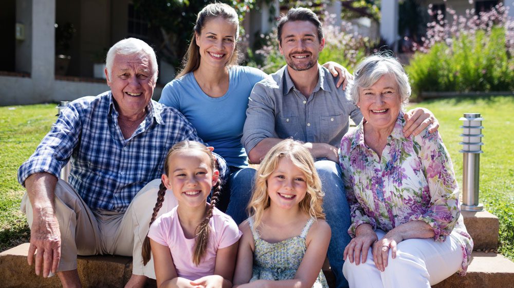 multi-generation-family-sitting-garden three generations of a family sitting in a garden