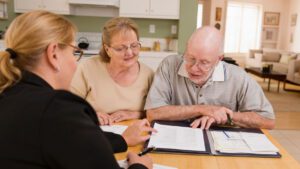 older couple sitting at kitchen table with aged care adviser