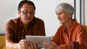 Older woman and her adult son reviewing aged care support information at a dining table