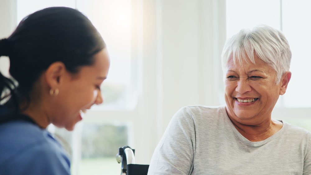 Smiling support at home care worker with older person