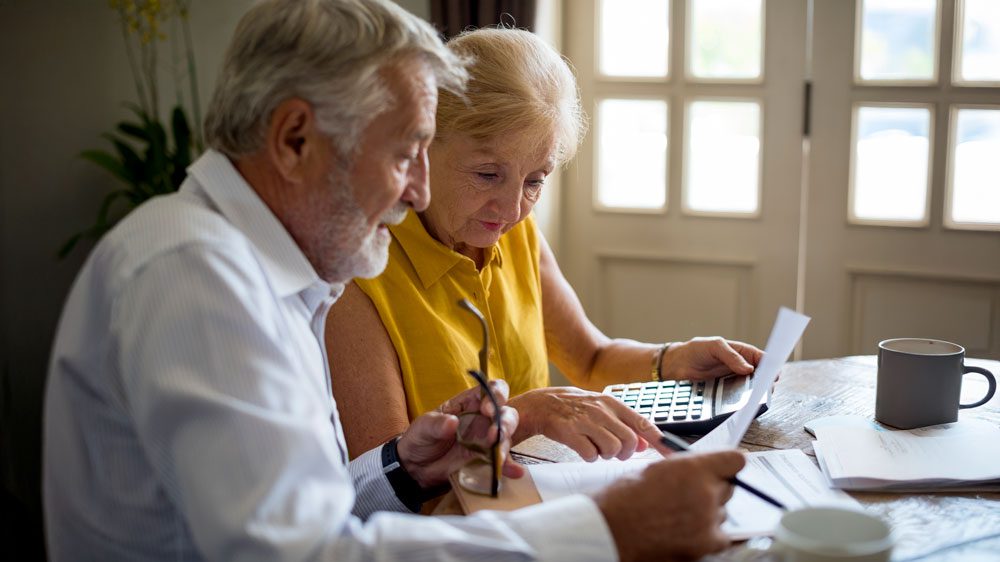 senior couple calculating aged care fees at a table